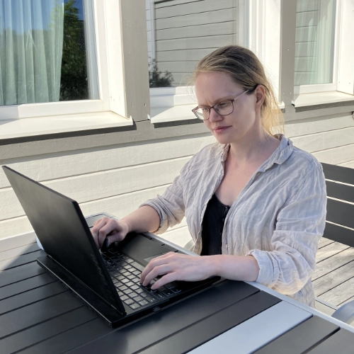Linda Marteliusson Sitter Och Skriver På En Laptop Vid Ett Bord Utomhus Lm Webb Ab